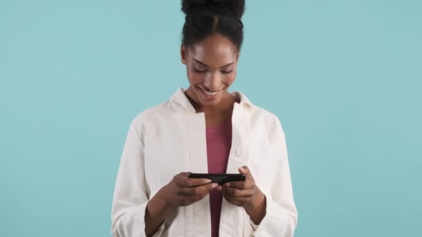 Beautiful Smiling Casual African American Girl Joyfully Using Cellphone Horizontally — Stock Video