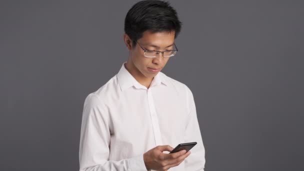 Joven Pensativo Asiático Hombre Gafas Usando Celular Reflexivamente Mirando Lejos — Vídeos de Stock