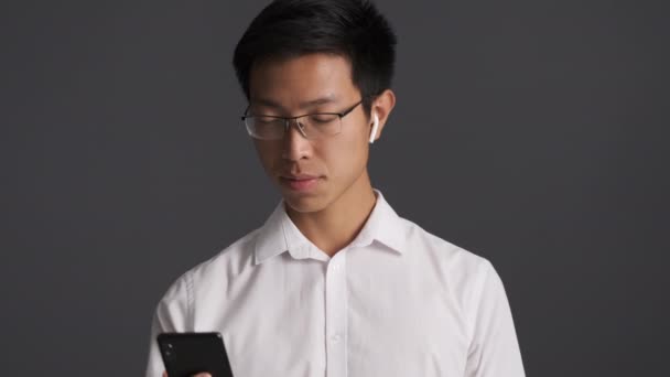 Jovem Bonito Sorrindo Asiático Homem Óculos Alegremente Acenando Mão Falando — Vídeo de Stock