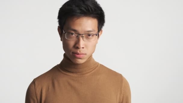 年轻而严肃的亚洲男人戴着眼镜 咄咄逼人地展示食指 并在相机上孤立地进行威胁 你在深深的烦恼中 — 图库视频影像