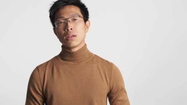 Ung Irriterad Asiatisk Man Glasögon Trött Täcka Ansikte Isolerad Ansiktsuttryck — Stockvideo