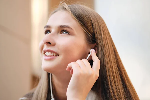 Portrait of positive student girl in earphone joyfully looking away outdoor — Stok Foto