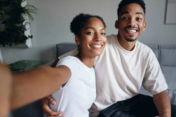 Jovem alegre casal afro-americano casual feliz tomando selfie juntos em casa moderna — Fotografia de Stock