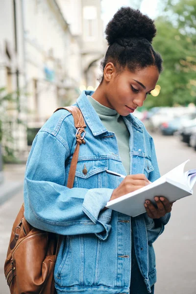 Houkutteleva rento Afrikkalainen Amerikkalainen opiskelija tyttö denim takki reppu opiskelu kaupungin kadulla — kuvapankkivalokuva