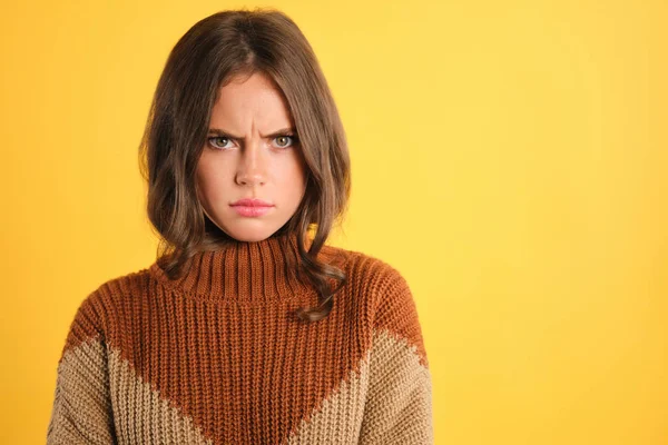 Retrato de chica molesta en suéter acogedor enojado mirando en la cámara sobre fondo colorido —  Fotos de Stock