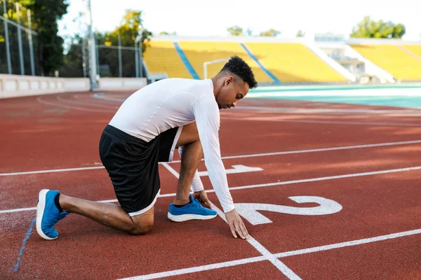 도시 경기장에서 경주 트랙에서 달릴 준비를 하고 있는 매력적 인 젊은 아프리카 계 미국인 스포츠맨 — 스톡 사진