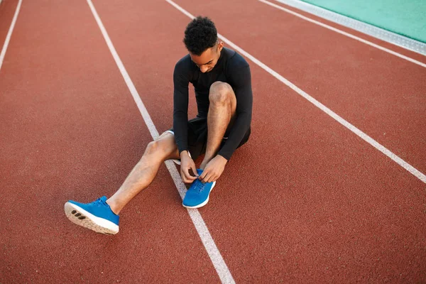 경주 용 경기장에서 운동화에 구두끈을 매고 있는 아프리카 계 미국인 청년 — 스톡 사진