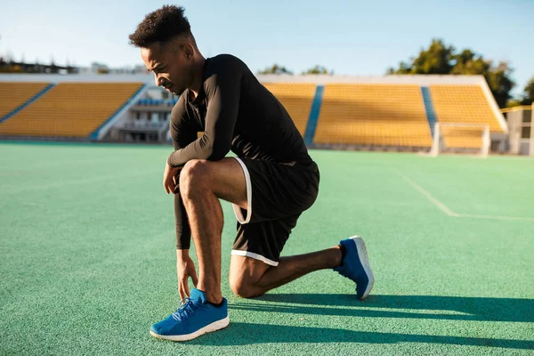 경기장에서 열심히 운동하는 젊은 아프리카 계 미국인 운동 선수의 측면 사진 — 스톡 사진