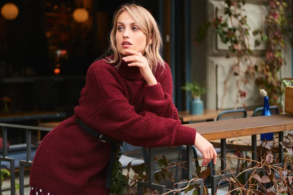 Muchacha rubia atractiva en suéter de punto cuidadosamente mirando al aire libre —  Fotos de Stock