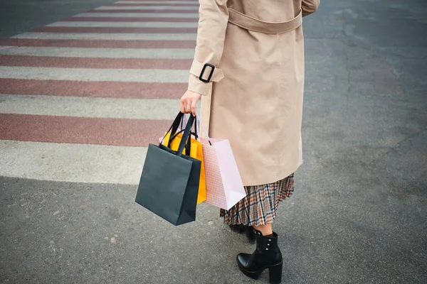 Закрыть стильную женщину с сумками для покупок, идущую по пешеходному переходу — стоковое фото