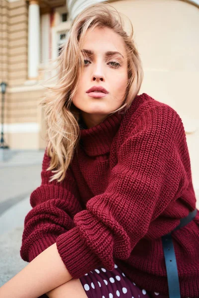 Attractive stylish blond girl in knitted sweater looking in camera sensually posing outdoor — Stock Photo, Image