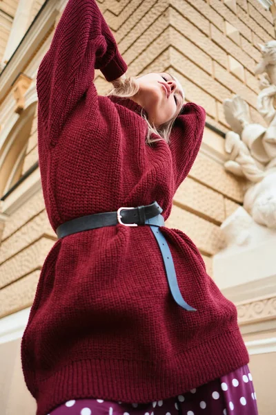 Концептуальная фотография стильной блондинки в трикотажном свитере, чувственно позирующей на открытом воздухе — стоковое фото