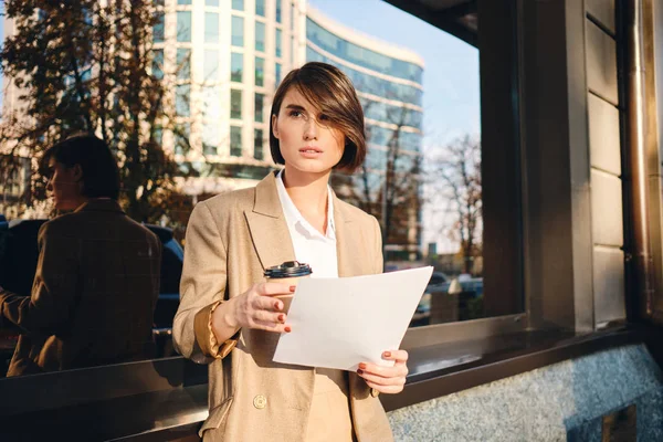 Giovane bella donna d'affari seria con il caffè per andare a lavorare con attenzione sulla strada — Foto Stock