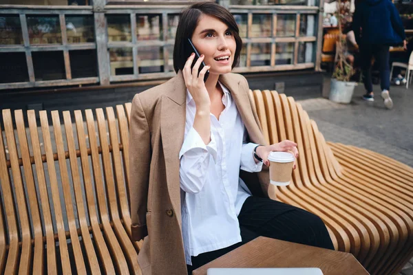 Młoda atrakcyjna stylowa bizneswoman rozmawiająca przez telefon podczas przerwy kawowej w kawiarni na ulicy — Zdjęcie stockowe