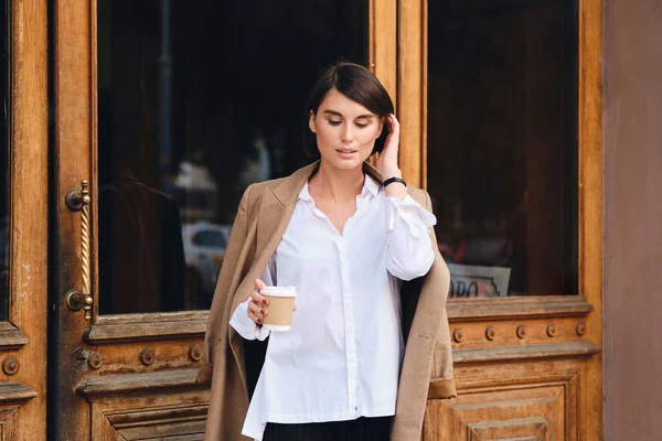 Junge schöne stilvolle Geschäftsfrau mit Kaffee zum verträumten Stehen im Freien — Stockfoto
