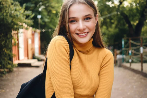 Güzel gülümseyen öğrenci kızın portresi. Şehir parkında kameraya mutlu bir şekilde bakıyor. — Stok fotoğraf