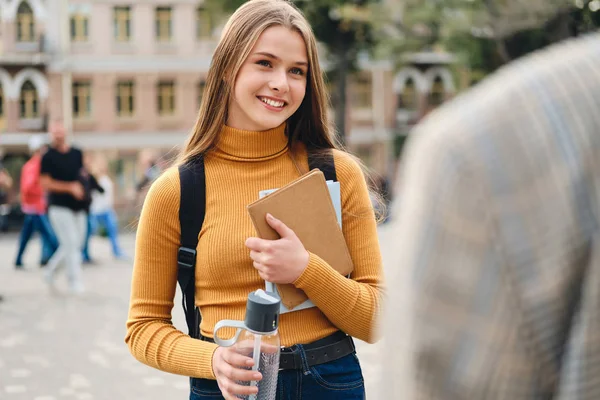 Schöne lächelnde Studentin im fröhlichen Gespräch mit Freundin Durin — Stockfoto