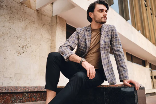 Jovem homem atraente em elegante jaqueta quadriculada confiantemente olhando para o exterior — Fotografia de Stock