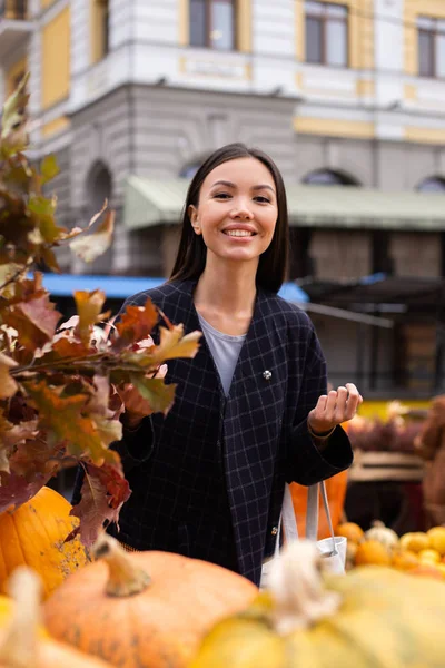Nuori iloinen rento nainen onnellisesti etsii kameran syksyllä maatilan myymälä ulkona — kuvapankkivalokuva