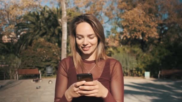Tracking Shot Του Όμορφου Κοριτσιού Χρησιμοποιώντας Smartphone Μηνύματα Τους Φίλους — Αρχείο Βίντεο