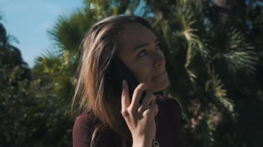 Şehir parkında arkadaşıyla telefonda konuşan çekici bir kızın fotoğrafını çekiyorum.