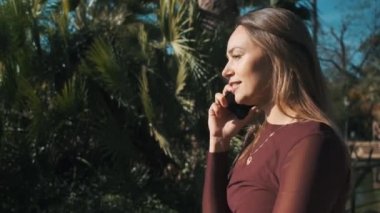 Parkta yürürken, yeşil gözlü, akıllı telefondan konuşan ve saçlarına dokunan güzel sarışın kızın portresini çiziyorum.