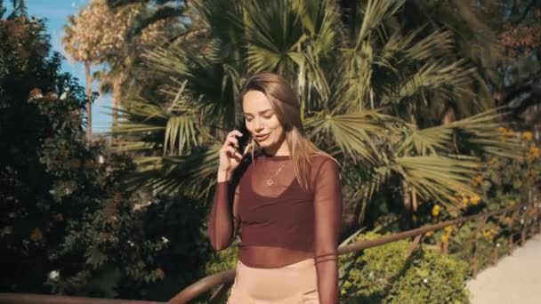 Seguimiento Alrededor Toma Hermosa Chica Elegante Felizmente Hablando Teléfono Inteligente — Vídeo de stock