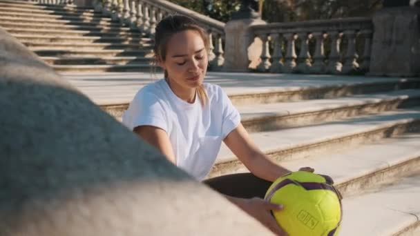 Conceptual Śledzenia Strzał Pięknej Dziewczyny Piłką Nożną Rękach Siedzi Schodach — Wideo stockowe
