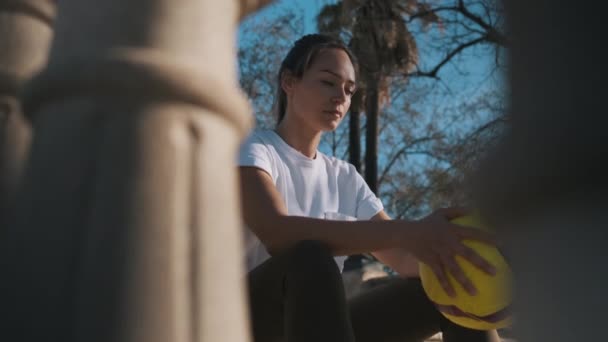 Conceptual Shot Pięknej Sportowej Dziewczyny Piłką Nożną Rękach Siedzi Schodach — Wideo stockowe