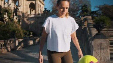 Şehir parkında futbol yeteneklerini sergileyen güzel bir kızın fotoğrafını çekiyorum. Futbolcu kız tekme atıyor. 