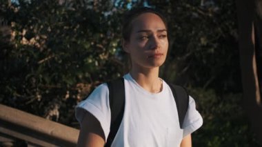 Futbolcu kızın elinde bir futbol topuyla parkta birini beklerken çekilen görüntülerini izliyorum.