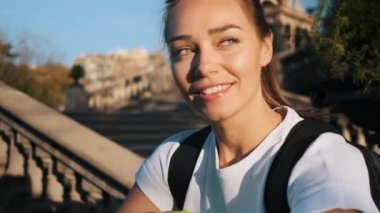 Eğitimden sonra parkta mutlu bir şekilde dinlenen akıllı telefonlu çekici, gülümseyen futbolcu kızın portresini çiziyorum. 