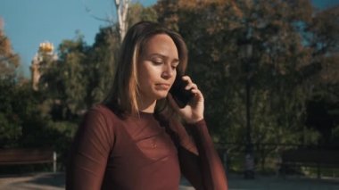 Çekici bir kızın erkek arkadaşıyla telefonda konuşurken görüntüsü. Üzücü ve hayal kırıklığına uğramış bir şekilde telefonu kapatıyor.
