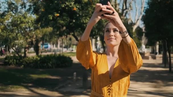 Sledování Záběru Mladé Nádherné Ženy Soustředěně Fotografování Smartphone Městském Parku — Stock video