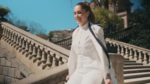 古い都市公園の階段を下って実行されている古典的な白いスーツの若い豪華な女性 優雅な実業家が会いに急いで — ストック動画