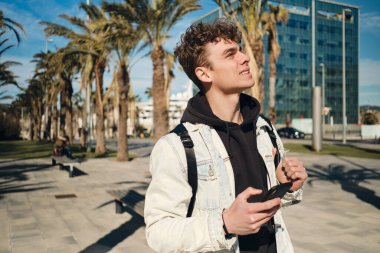 Şehir caddesinde akıllı telefonlu yakışıklı, sıradan bir adam. Genç turist yeni şehri keşfediyor.