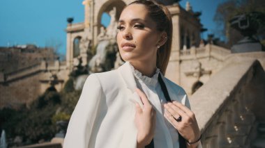 Güzel, zarif bir kadının portresi dikkatle parka bakıyor eski mimariyle.