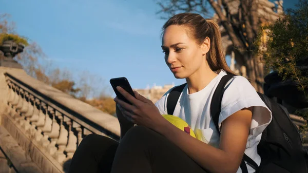 Kaunis Tyttö Jolla Reppu Jalkapallo Älypuhelimella Vanhoissa Portaissa Kaupungin Puistossa — kuvapankkivalokuva