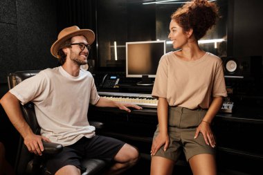 Modern ses kayıt stüdyosunda birlikte çalışarak mutlu mesut birbirlerine bakan genç müzisyenler.