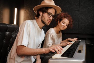 Genç müzisyenler, modern ses kayıt stüdyosunda birlikte çalışarak rüyalarında piyano klavyesinde müzik besteliyorlardı.