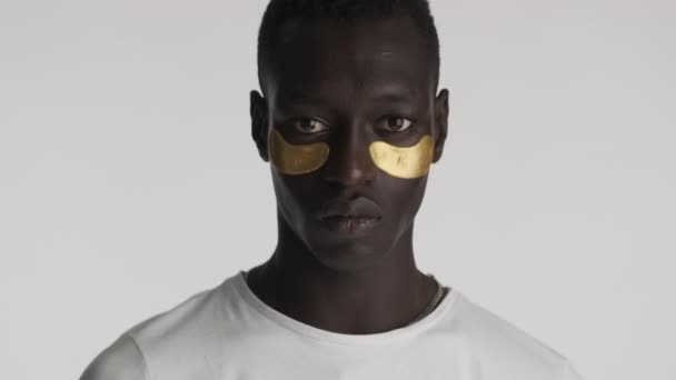 Portret Poważnego Afroamerykanina Złotymi Opaskami Oczach Uważnie Patrzącego Kamerę Wymachującego — Wideo stockowe