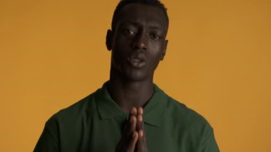 Genç üzgün afro-amerikalı adam lütfen renkli arka planda hareket edin. Lütfen ifade et