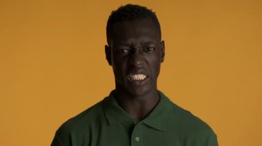 Genç, duygusal, Afro-Amerikalı bir adam, renkli geçmişinden iğrenerek kameraya bakıyor.
