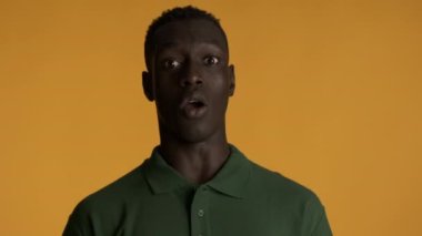 Genç, korkmuş Afrikalı Amerikalı adam renkli geçmişinde dur hareketi yapıyor. İfadeyi izlemek istemiyorum.