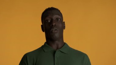 Genç şok olmuş Afrikalı Amerikalı adam renkli geçmişinden tiksinerek kameraya bakıyor.