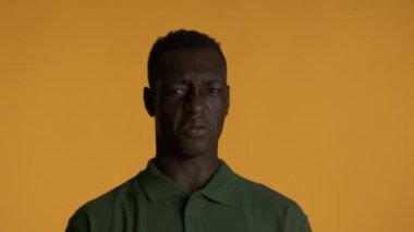 Genç üzgün Afro-Amerikan bir adam. Renkli arka plandaki kötü koku yüzünden burnunu sıkıyor. Berbat ifade