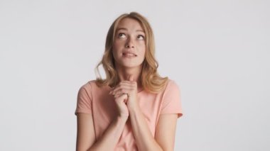 Güzel sarışın kız el ele tutuşup gri arka planda hayal kuruyor. Hüzünlü ifade