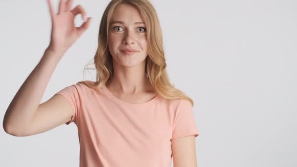 Vonzó Vicces Szőke Lány Boldogan Mutat Gesztust Kamera Előtt Szürke — Stock videók