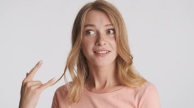 Güzel, cilveli sarışın kız gri arka planda beni ara. Telefon hareketi