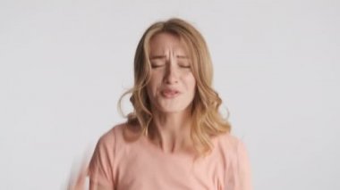 Kaprisli sarışın kadın gri arka plandaki bir şeyden memnun değil. Hoşnutsuz ifade